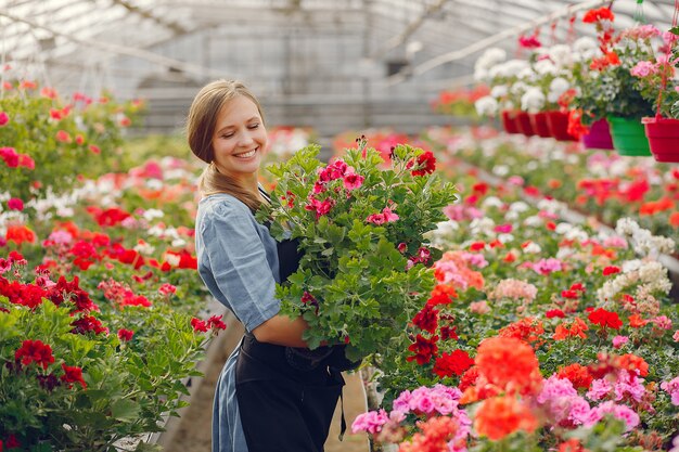 Woman in a black apron working in a greenhouse