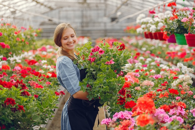 Woman in a black apron working in a greenhouse