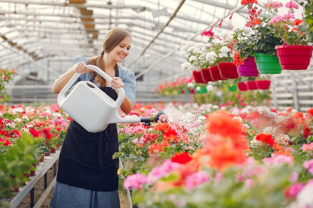 Woman in a black apron working in a greenhouse