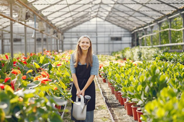 Woman in a black apron working in a greenhouse