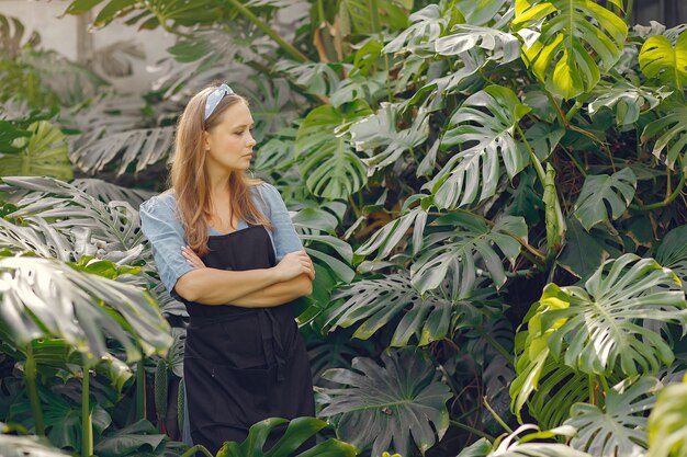 Woman in a black apron working in a greenhouse