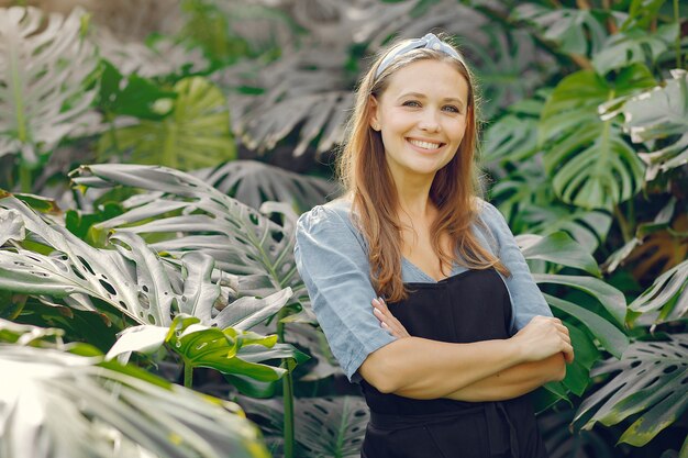 Woman in a black apron working in a greenhouse