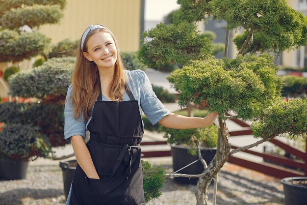 Woman in a black apron working in a greenhouse