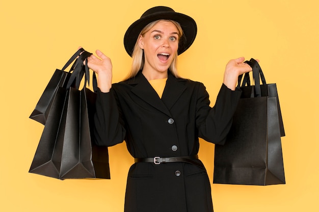 ショッピング黒い袋を保持している黒い金曜日の販売の女性