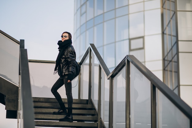 Free photo woman in black jacket walking through the bridge