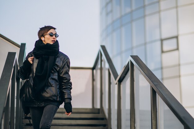 Woman in black jacket walking through the bridge