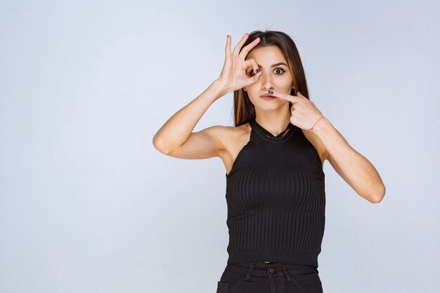 Woman in black shirt making positive hand sign. 