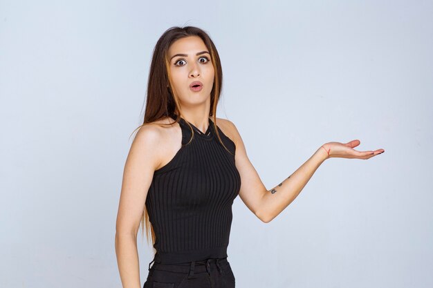 Woman in black shirt making presentation using open hands. 