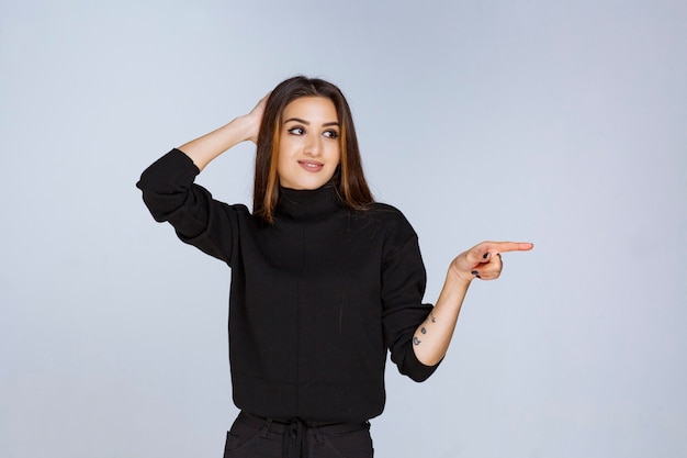 woman in black shirt pointing something on the right. 