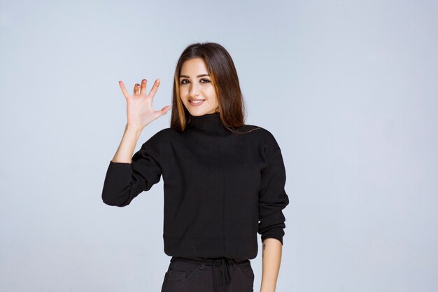 woman in black shirt showing cat paws. 