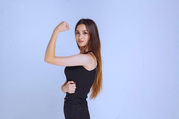 Woman in black shirt showing her fists and feeling powerful. 