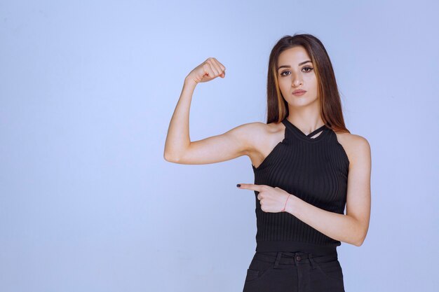 Woman in black shirt showing her fists and feeling powerful. 