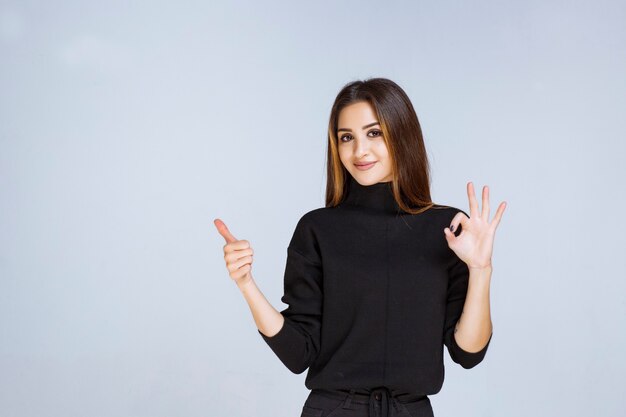 woman in black shirt showing positive hand sign. 