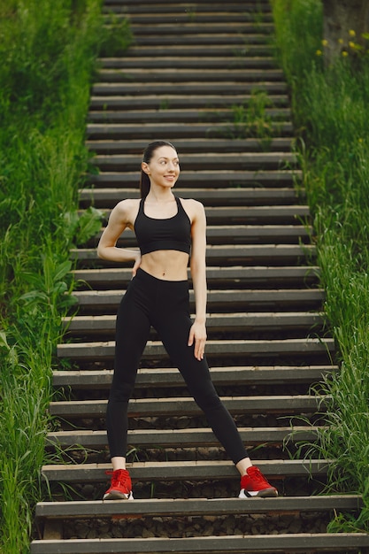 Woman in a black spoerswear standing on a stairs