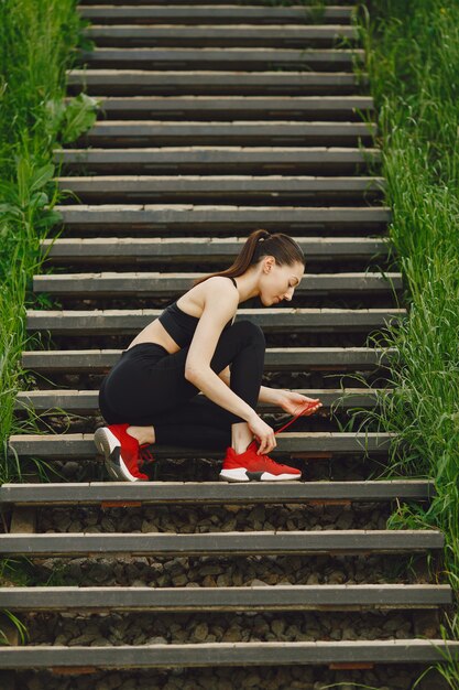 Woman in a black spoerswear standing on a stairs