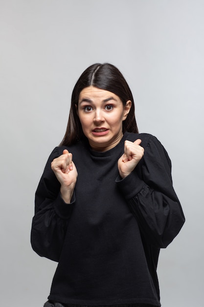Woman in black sweater demonstrates fear