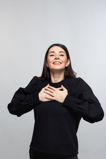 Woman in black sweater demonstrates happiness