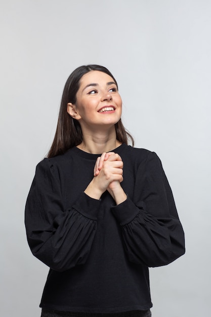 Woman in black sweater demonstrates happiness