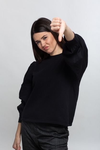 Женщина в черном свитере показывает низом