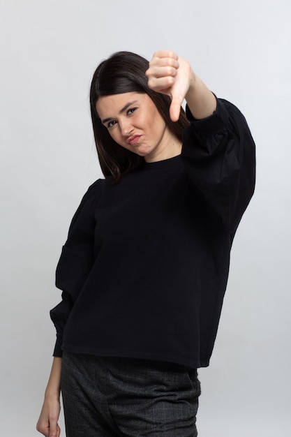 Woman in black sweater shows thubs down