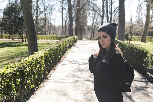 Free photo woman in black with backpack on street