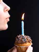 Foto gratuita donna che soffia in una candela di compleanno