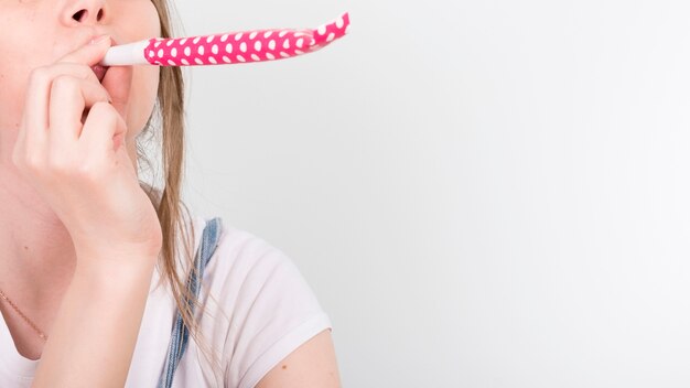 Woman blowing festive party horn