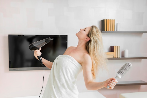 Woman blowing her hair with a dryer