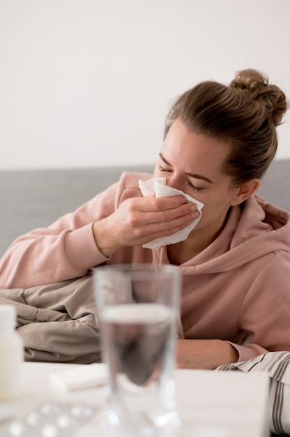 Woman blowing her nose and being indoors