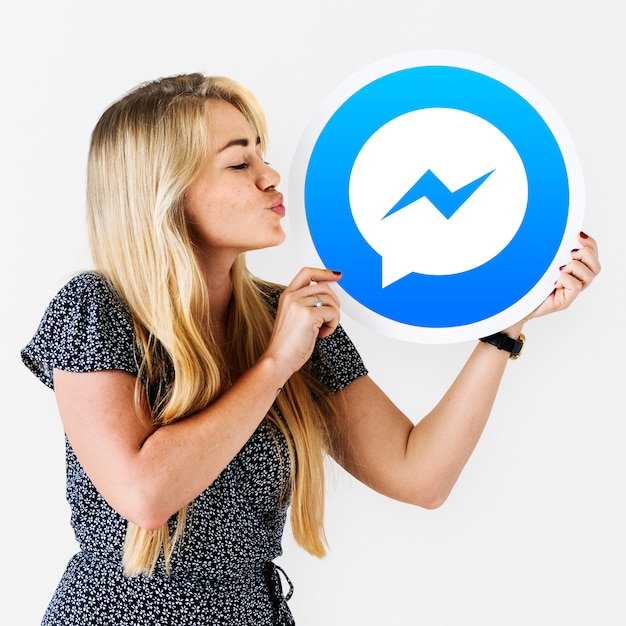 Женщина дует поцелуй в значок Facebook Messenger