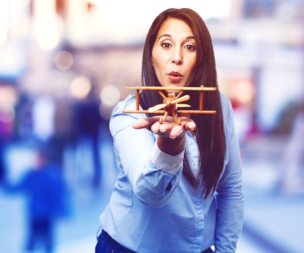 Woman blowing a wooden plane