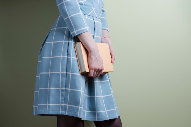 Woman in blue dress holding a book