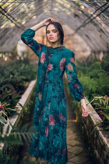 Woman in blue floral dress looking at camera