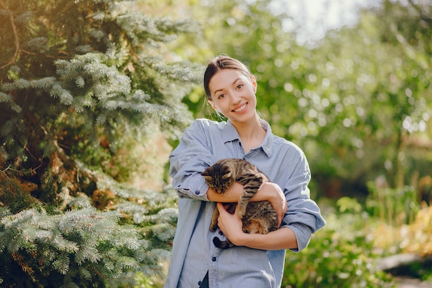 woman in a blue shirt playing with cute kitty