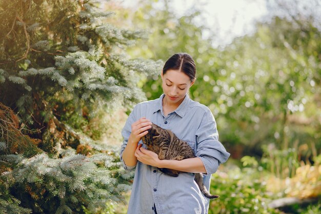 woman in a blue shirt playing with cute kitty