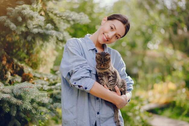 woman in a blue shirt playing with cute kitty