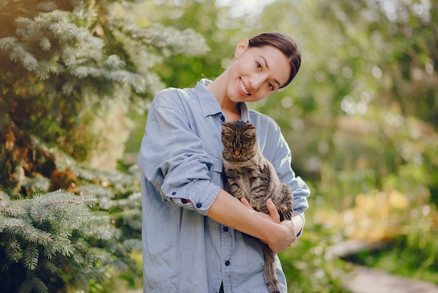 かわいい子猫と遊ぶ青いシャツを着た女性