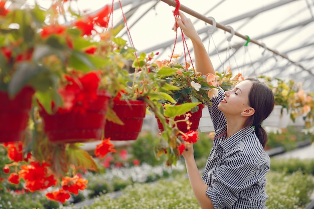 Woman in a blue shirt working in a greenhouse