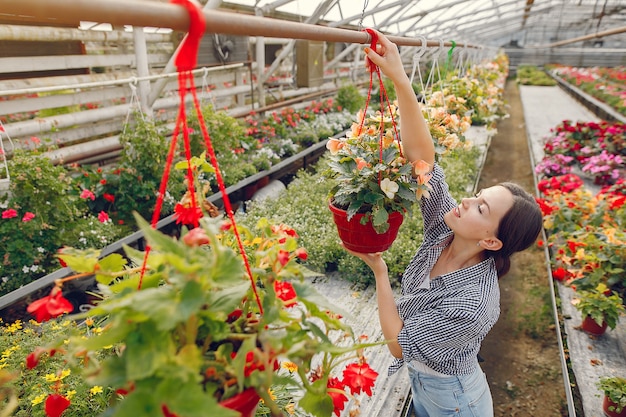 Woman in a blue shirt working in a greenhouse