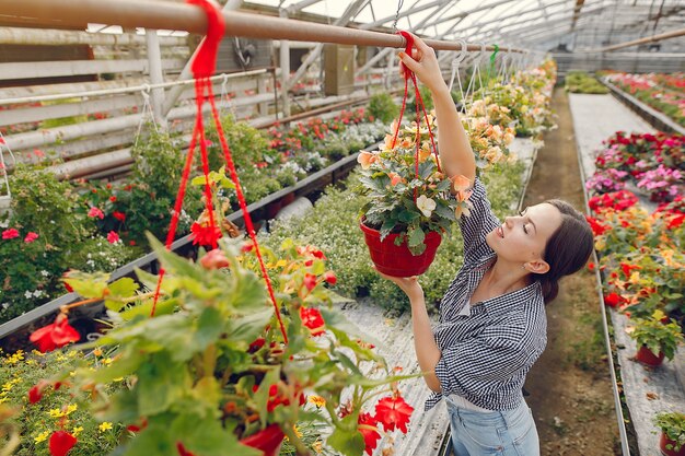 Woman in a blue shirt working in a greenhouse