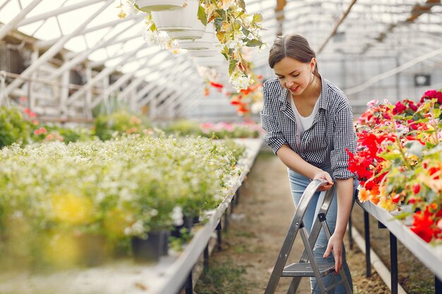 Woman in a blue shirt working in a greenhouse