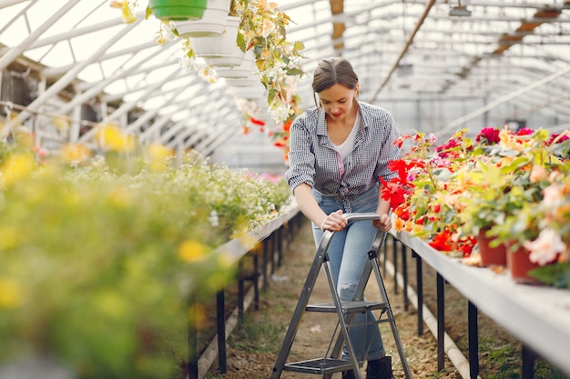 Woman in a blue shirt working in a greenhouse