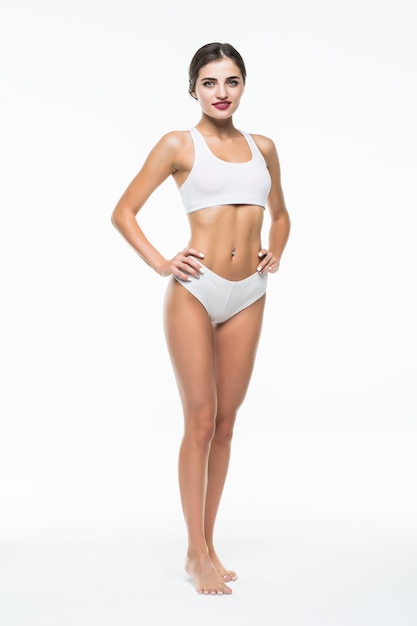 여자 몸 아름다움, 흰 벽에 고립 된 흰 속옷에 슬림 모델 산책