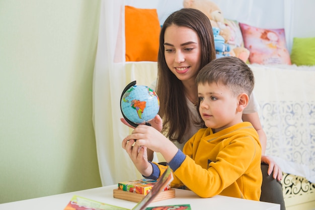 Woman and boy looking globe