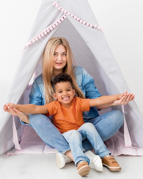 Woman and boy posing together in tent