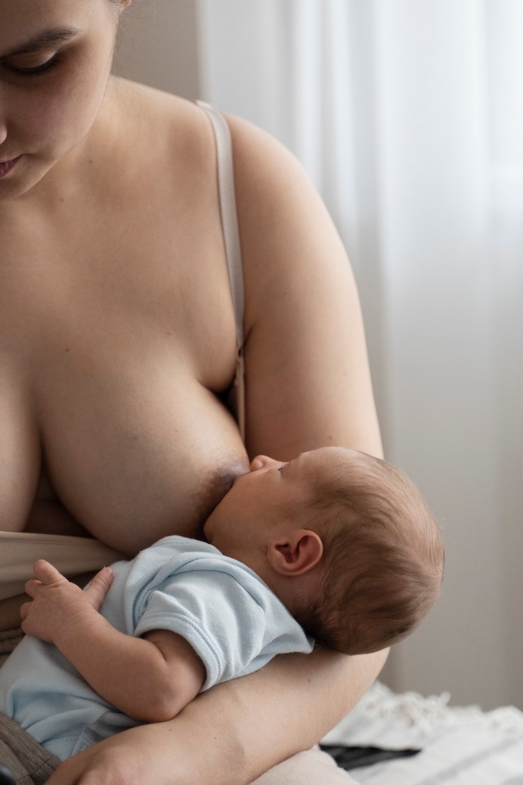 Free Photo woman breast feeding her child