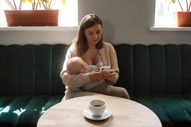 Foto gratuita donna che allatta al seno bambino al chiuso vista frontale