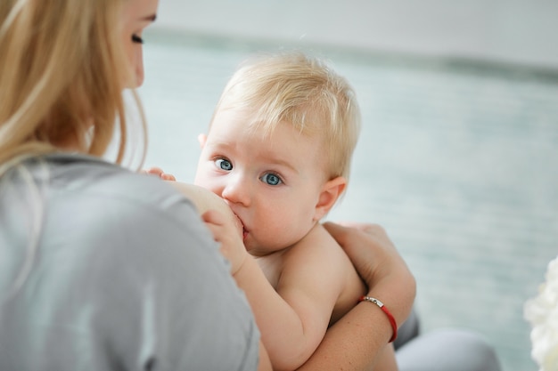 Woman breastfeeding little baby. Mother with her newborn daughter. 