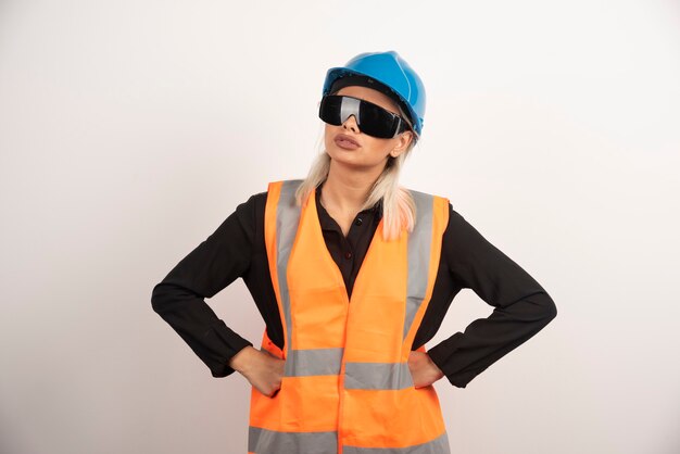 Woman builder posing with goggles and helmet. High quality photo