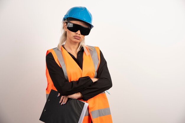 Woman builder with goggles and clipboard . High quality photo